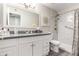 Bright bathroom with large vanity, framed mirror, shower with curtain, and gray plank flooring at 11427 S Tomah St, Phoenix, AZ 85044