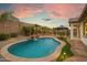An inviting backyard pool with a waterfall feature and gazebo under a picturesque sky at 12528 W Tuckey Ln, Glendale, AZ 85307