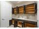 Spacious utility room offers ample storage with upper and lower dark cabinets and sink at 12528 W Tuckey W Ln, Glendale, AZ 85307