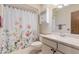 Bathroom with floral shower curtain and updated vanity at 14017 N 111Th Ave, Sun City, AZ 85351