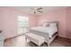 Bright bedroom with pink walls, queen bed, and ceiling fan at 14017 N 111Th Ave, Sun City, AZ 85351