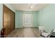 Light and airy bedroom with wood-look flooring and double doors at 14017 N 111Th Ave, Sun City, AZ 85351