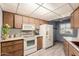 Kitchen with wood cabinets, granite countertops, and white appliances at 14017 N 111Th Ave, Sun City, AZ 85351