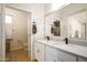 Bright bathroom featuring double sink vanity with bronze fixtures and a view into separate toilet room at 17850 N 68Th St # 3120, Phoenix, AZ 85054