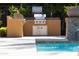 Outdoor kitchen area featuring a built-in BBQ grill next to a community pool at 17850 N 68Th St # 3120, Phoenix, AZ 85054