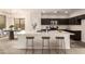 Modern kitchen with dark cabinetry, marble countertops, and breakfast bar at 1820 N 94Th Gln, Phoenix, AZ 85037