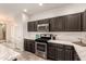 Modern kitchen with dark cabinets and stainless steel appliances at 1820 N 94Th Gln, Phoenix, AZ 85037