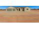 Tan house with three-car garage and desert landscaping at 19430 E Erik Ct, Florence, AZ 85132