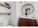 Clean powder room with a round mirror, wooden vanity, and floating shelves at 1956 W Black Hill Rd, Phoenix, AZ 85085