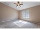 Neutral bedroom features carpeted floors, a ceiling fan, and natural light at 22235 E Cherrywood Dr, Queen Creek, AZ 85142