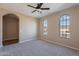 Neutral bedroom with arched windows and a ceiling fan at 22235 E Cherrywood Dr, Queen Creek, AZ 85142