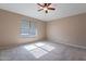 Spacious bedroom featuring neutral walls, plush carpet, and a ceiling fan for added comfort at 22235 E Cherrywood Dr, Queen Creek, AZ 85142