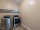 Laundry room features a stainless steel washer and dryer, with shelf at 22235 E Cherrywood Dr, Queen Creek, AZ 85142