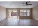 Bright living room features sliding glass doors, a ceiling fan and wood-look tile flooring at 22235 E Cherrywood Dr, Queen Creek, AZ 85142