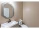 Stylish powder room with custom mirror, white sink and toilet at 22235 E Cherrywood Dr, Queen Creek, AZ 85142