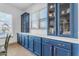 Bright kitchen with blue cabinetry, a large window, and a wooden table at 22812 E Excelsior Ave, Queen Creek, AZ 85142