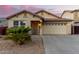 Tan house with a two-car garage and desert landscaping at 24246 W Tonto St, Buckeye, AZ 85326