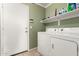 Clean laundry room with washer, dryer, and storage shelves at 24246 W Tonto St, Buckeye, AZ 85326