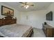 Main bedroom with TV, ceiling fan and large bed at 2524 W Saint Catherine Ave, Phoenix, AZ 85041