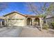 Tan house with arched entryway, two-car garage, and desert landscaping at 2524 W Saint Catherine Ave, Phoenix, AZ 85041