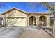 Tan house with arched entryway, two-car garage, and desert landscaping at 2524 W Saint Catherine Ave, Phoenix, AZ 85041