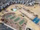 Aerial view of community park that includes a pool, playgrounds, tennis courts, volleyball court, and picnic area at 30968 W Monterey Ave, Buckeye, AZ 85396