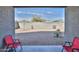 View of the backyard with gravel, block wall, and chairs from a covered patio at 30968 W Monterey Ave, Buckeye, AZ 85396