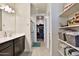 Bright bathroom featuring a vanity, a mirror, and a shower, with a view into a closet at 30968 W Monterey Ave, Buckeye, AZ 85396