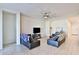 Open-concept living room with tile flooring, ceiling fan, and comfortable leather furniture at 30968 W Monterey Ave, Buckeye, AZ 85396