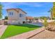 Spacious backyard featuring lush artificial turf, a covered patio, and beautiful landscaping at 3352 E Hopi Ave, Mesa, AZ 85204