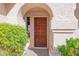 Inviting front door with arched entry and a lush garden, creating a warm and welcoming entrance at 3352 E Hopi Ave, Mesa, AZ 85204