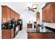 Open concept kitchen with stainless steel appliances, wooden cabinets and black countertops at 3352 E Hopi Ave, Mesa, AZ 85204