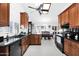 Well-lit kitchen with granite countertops, black appliances and white tiled floors at 3352 E Hopi Ave, Mesa, AZ 85204