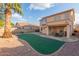 Two-story home with a backyard featuring a putting green and patio at 4248 E Raven Rd, Phoenix, AZ 85044