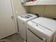 Functional laundry room with modern white washer and dryer units at 43726 W Carey Dr, Maricopa, AZ 85138