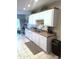 View of the well-lit kitchen featuring white cabinets, tile floors, and stainless steel sink at 455 S Delaware Dr # 117, Apache Junction, AZ 85120