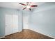 Bedroom featuring blue walls, wood floors, ceiling fan, and closet at 505 W Wayland Dr, Phoenix, AZ 85041