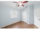 Bedroom featuring blue walls, wood floors, ceiling fan, and closet at 505 W Wayland Dr, Phoenix, AZ 85041