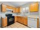 Close up view of a kitchen with wood cabinets, tile flooring, and stainless sink at 505 W Wayland Dr, Phoenix, AZ 85041