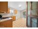 Well-lit kitchen featuring wooden cabinetry, stainless steel sink, and tile floors at 505 W Wayland Dr, Phoenix, AZ 85041