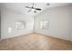 Living room with vaulted ceiling, neutral walls, tile floors, and multiple windows at 505 W Wayland Dr, Phoenix, AZ 85041