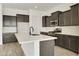 Modern kitchen with dark cabinets, white countertops, and island at 5509 N 193Rd Ave, Litchfield Park, AZ 85340