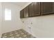 Laundry room with upper cabinets and patterned floor at 5509 N 193Rd Ave, Litchfield Park, AZ 85340