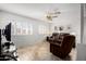 Gathering room with a ceiling fan, brown leather recliners, and a TV at 6457 E Dallas St, Mesa, AZ 85205