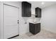 Laundry room with dark cabinets, quartz countertop and hexagon tile floor at 6547 E Eugie Ter, Scottsdale, AZ 85254