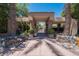 Welcoming entrance with a gate, surrounded by desert landscaping and a clear blue sky at 7400 E Gainey Club Dr # 222, Scottsdale, AZ 85258