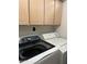 Convenient laundry room features overhead cabinets and modern washer and dryer appliances at 7400 E Gainey Club Dr # 222, Scottsdale, AZ 85258