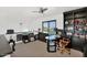 Well-lit home office with a dark wood desk, ceiling fan, built-in shelving, and a window providing natural light at 7400 E Gainey Club Dr # 222, Scottsdale, AZ 85258