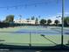 Well-maintained tennis courts with a fence and the community in the background under a blue sky at 7400 E Gainey Club Dr # 222, Scottsdale, AZ 85258