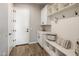 Bright laundry room with white cabinets, a utility sink, and modern washer/dryer at 7460 E Via De Luna Dr, Scottsdale, AZ 85255